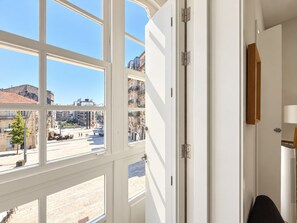 A room with large windows, a door, and a view of a city street.