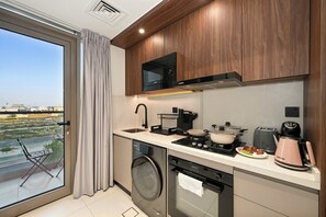 A modern kitchen with a built-in oven, microwave, and coffee maker. - Bloomfields Studio in Torino by Oro24 (Dubai)