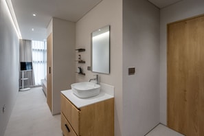 Un bany modern amb un gran mirall, un lavabo de disseny i mobles de fusta.