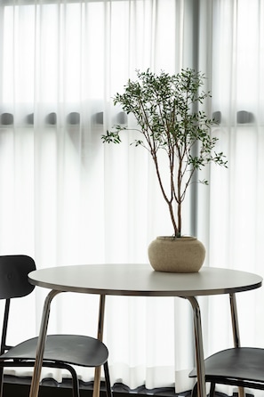 Une table ronde ornée d’une plante en pot au centre, avec deux chaises de chaque côté.