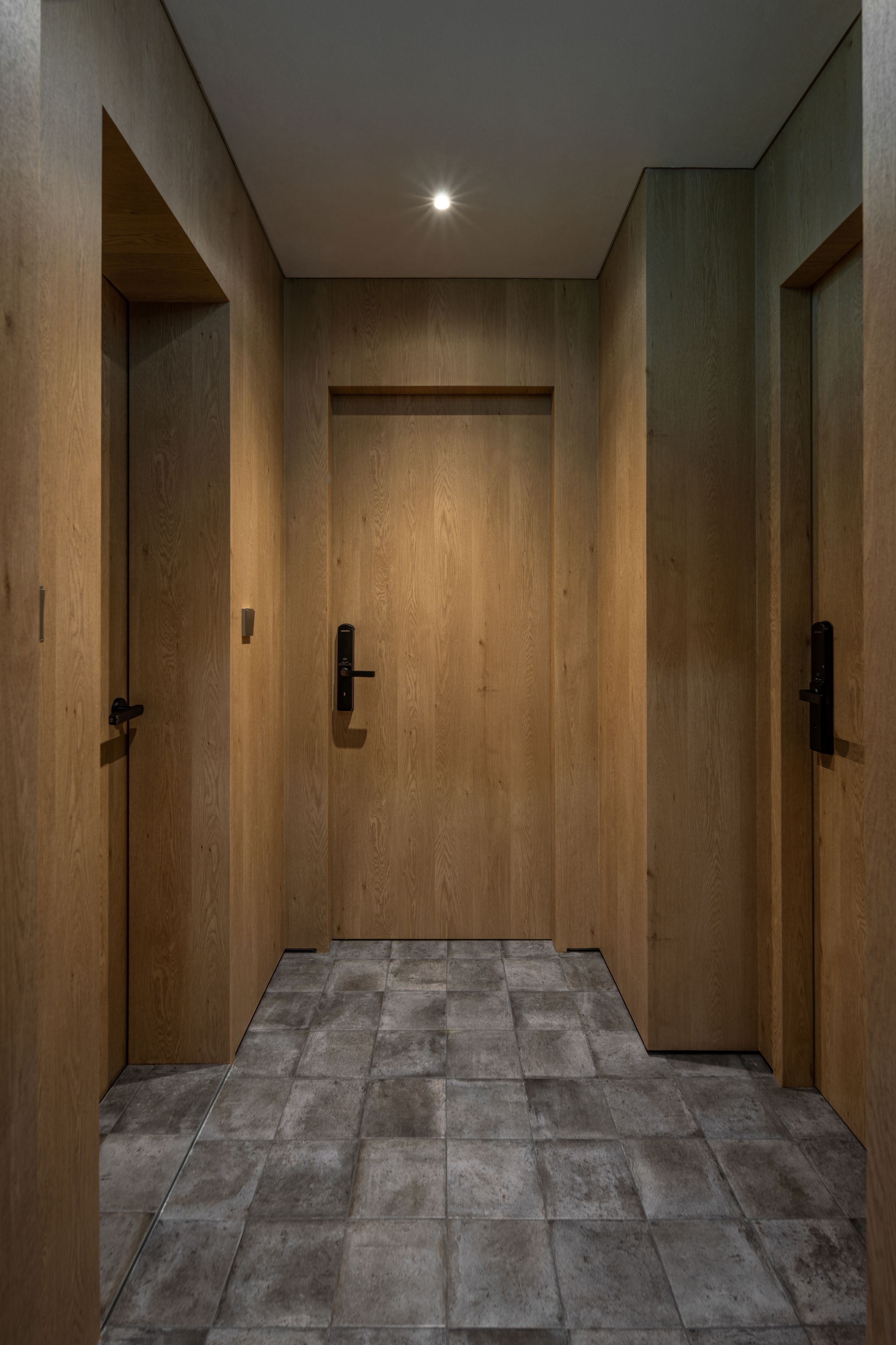 A hallway with wooden doors and a tiled floor.