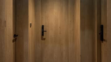 A hallway with wooden doors and a tiled floor.