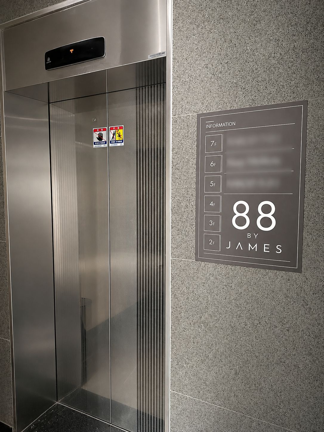 An elevator with a digital display showing the number 88 and the name 'James'.