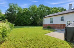 A residential property with a well-maintained lawn, a brick foundation, and a covered outdoor area. - DC Area Apt w Fenced Yard - 1 Mi to Metro! (Silver Spring)