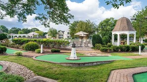 Un parcours de minigolf doté d’un kiosque, d’une pelouse parfaitement entretenue et d’un ciel dégagé.