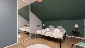Une chambre à coucher avec un lit, une chaise, un miroir et une lampe.