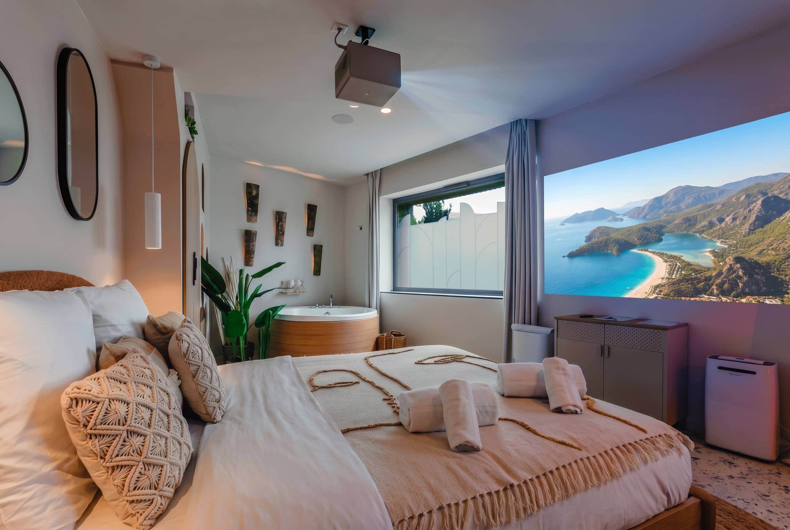 A bedroom with a large bed, a bathtub, and a view of a coastal landscape.