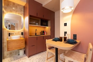 A modern kitchen with a wooden countertop, a sink, and a dining table with chairs. - Romantic Suite in Ibiza | Sauna | Spa (Strasbourg)