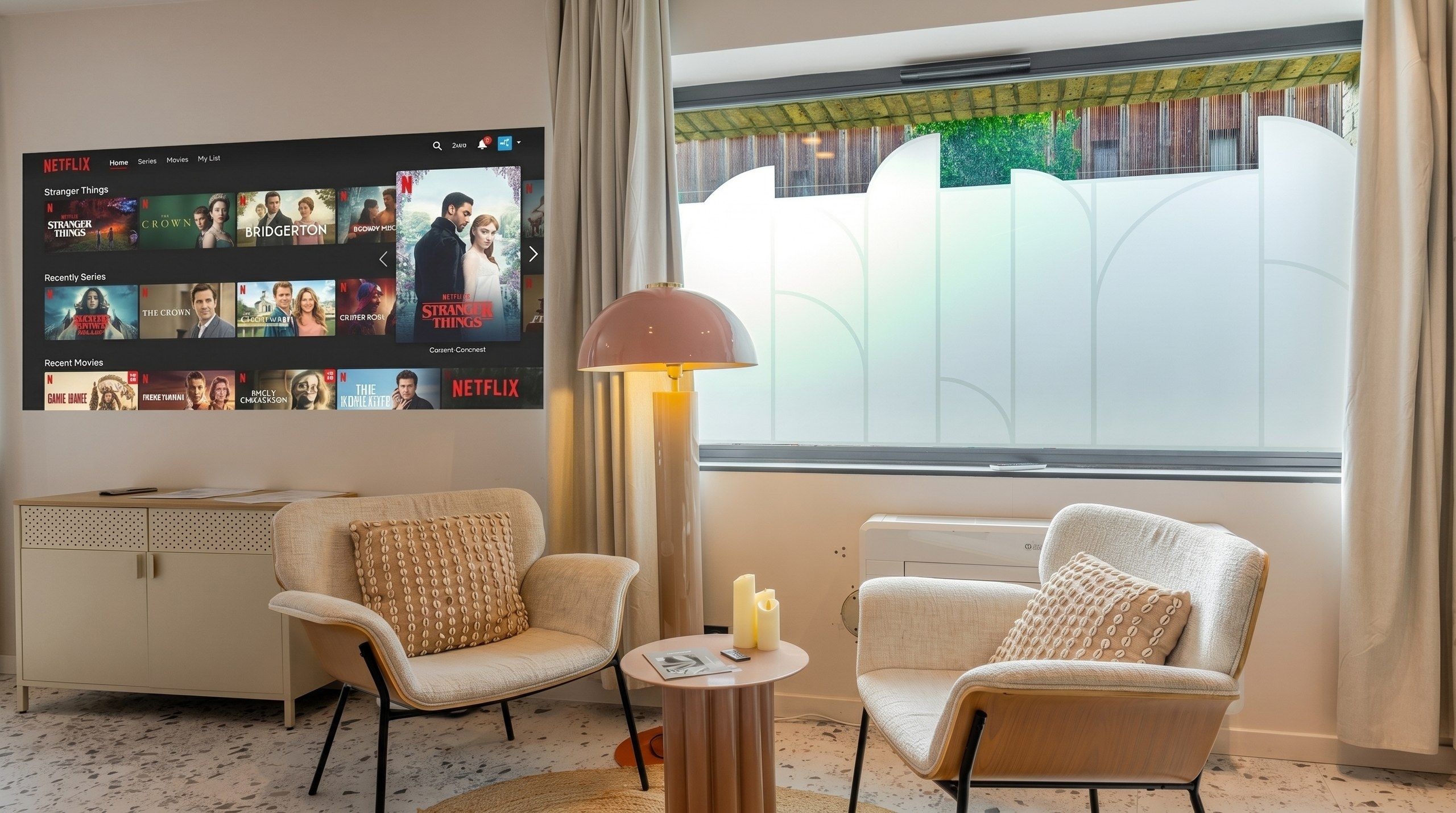 Een moderne woonkamer met een grote tv waarop een Netflix-interface zichtbaar is, twee fauteuils, een bijzettafeltje met een lamp en uitzicht op groen door een raam.