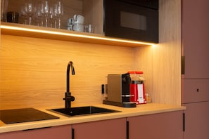 A compact kitchen with a black sink, a coffee machine, and a microwave. - Romantic Suite in Ibiza | Sauna | Spa (Strasbourg)