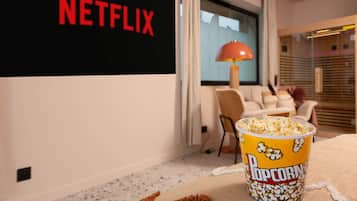 Ein Zimmer mit einem Netflix-Schild, einem Popcorntablett und einer Lampe.