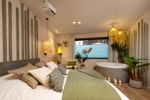 A modern bedroom with a large bed, a bathtub, and a window with a view. - Romantic Suite in Bali | Jacuzzi | Spa (Strasbourg)