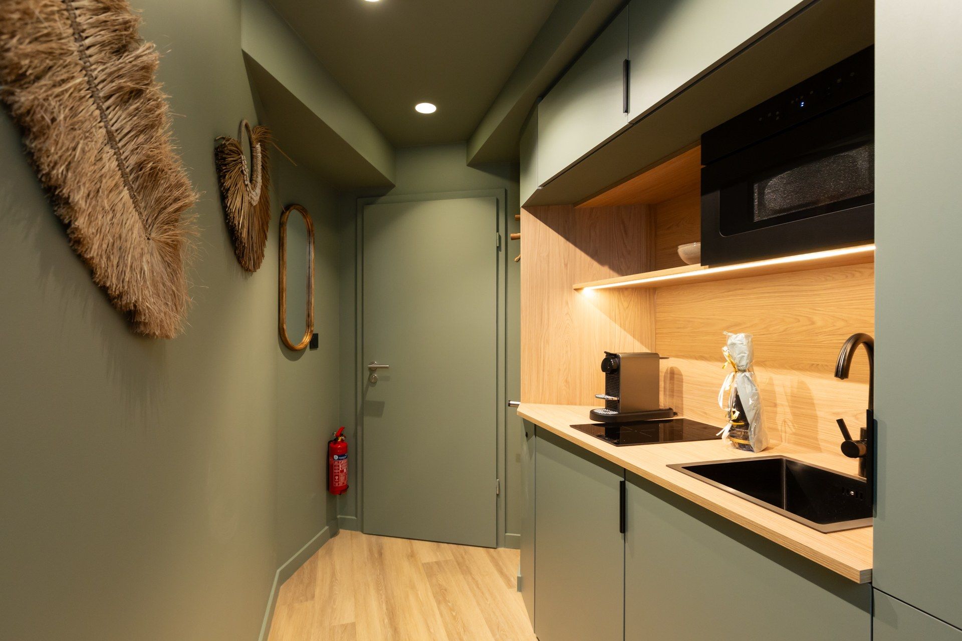 A modern kitchen with a built-in oven, a sink, and a wooden countertop.
