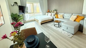 Ein modernes Schlafzimmer mit Bett, Sofa und Fernseher.