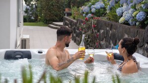 Een jacuzzi met twee personen die van een drankje genieten.