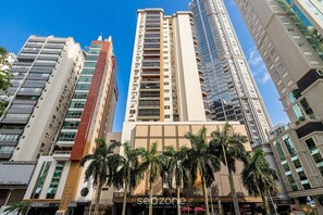 A multi-story building with a modern architectural design, featuring a prominent central tower and surrounding shorter buildings. - Apt. w/ Balcony and Sea View Mbn1003 (Balneário Camboriú)