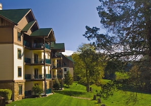 A multi-story building with balconies, surrounded by a well-maintained lawn and trees. - Sevierville | Pool & Mountains | Nature Escape Stay (Sevierville)