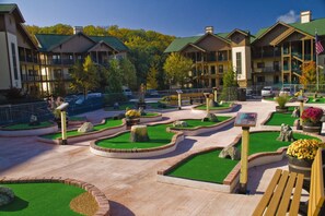 A resort with multiple-story buildings, landscaped gardens, and a paved courtyard. - Sevierville | Pool & Mountains | Nature Escape Stay (Sevierville)