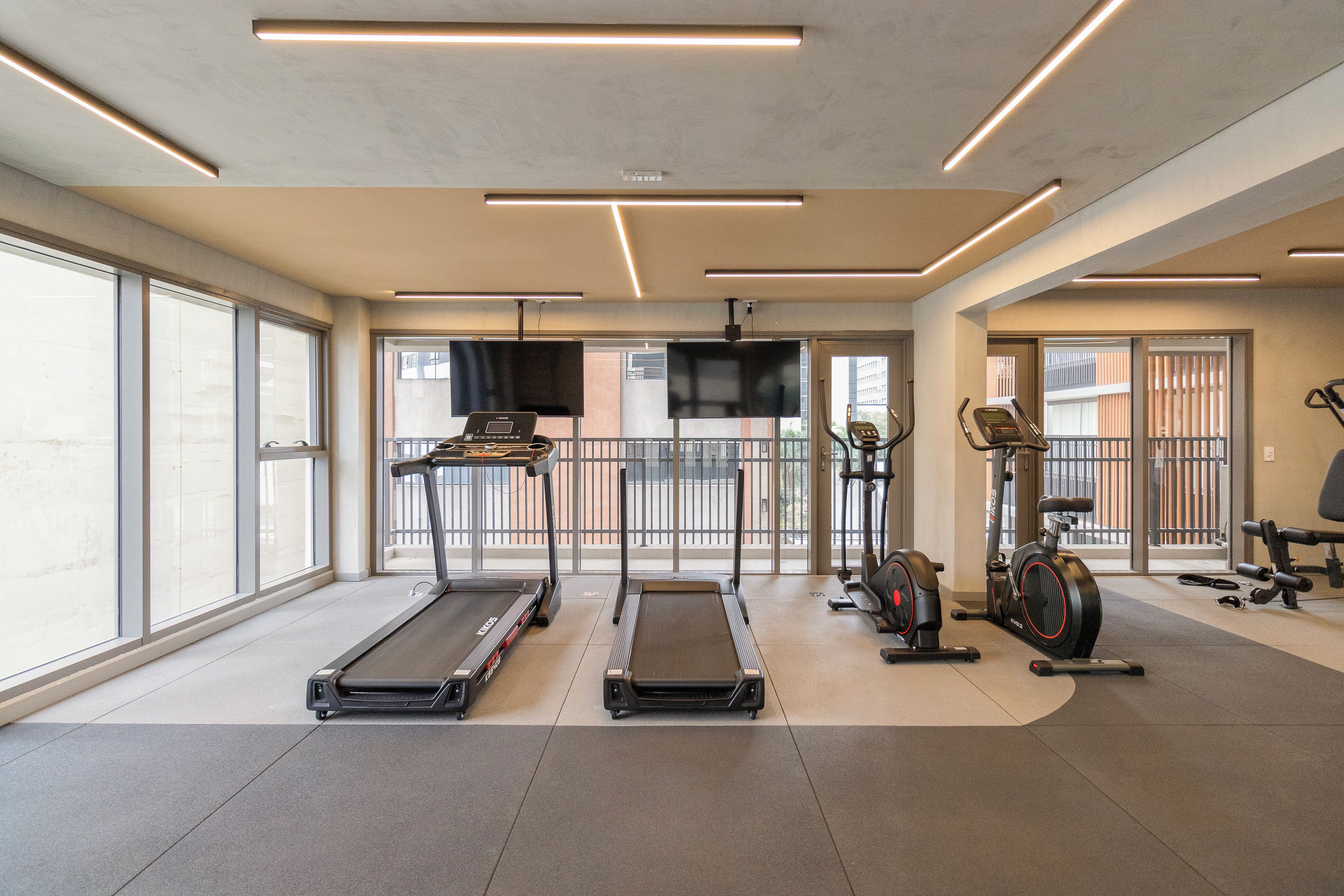 A gym with treadmills, stationary bikes, and exercise equipment.