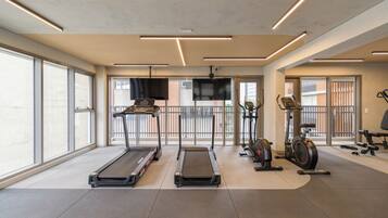 A gym with treadmills, stationary bikes, and exercise equipment.