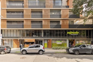 A multi-story building with a modern design, featuring a large glass storefront with signage for 'minuto' and 'PaideAcucar.' - Hpaulista By Bhomy (São Paulo)