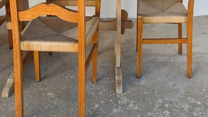 A wooden dining table with chairs, a green watering can, and a concrete floor. - Vrbo Property (Benavila)