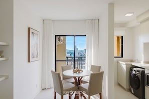 A modern apartment with a dining area, kitchen, and a balcony with a city view. - Apt. w/ Balcony in Condo. w/ Pool Mcb1003 (Picarras)