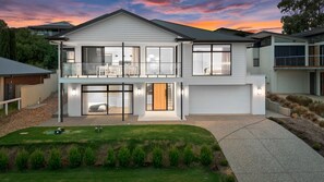 A two-story modern house with a balcony, large windows, and a well-maintained lawn. - Jewel of Carrickalinga - 14 Dorset Court (Carrickalinga)