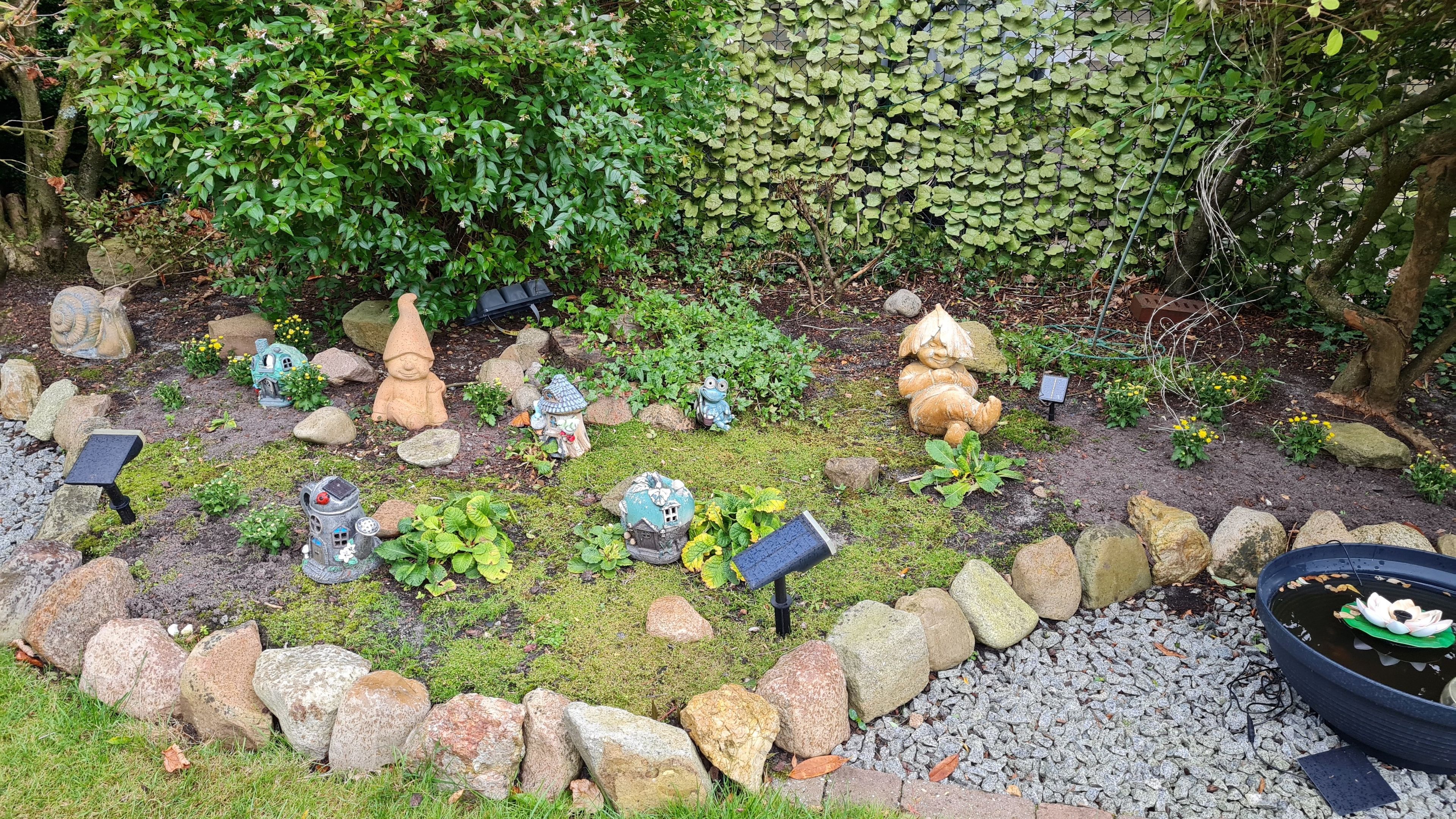 Ein Garten mit verschiedenen Statuen und Felsen.