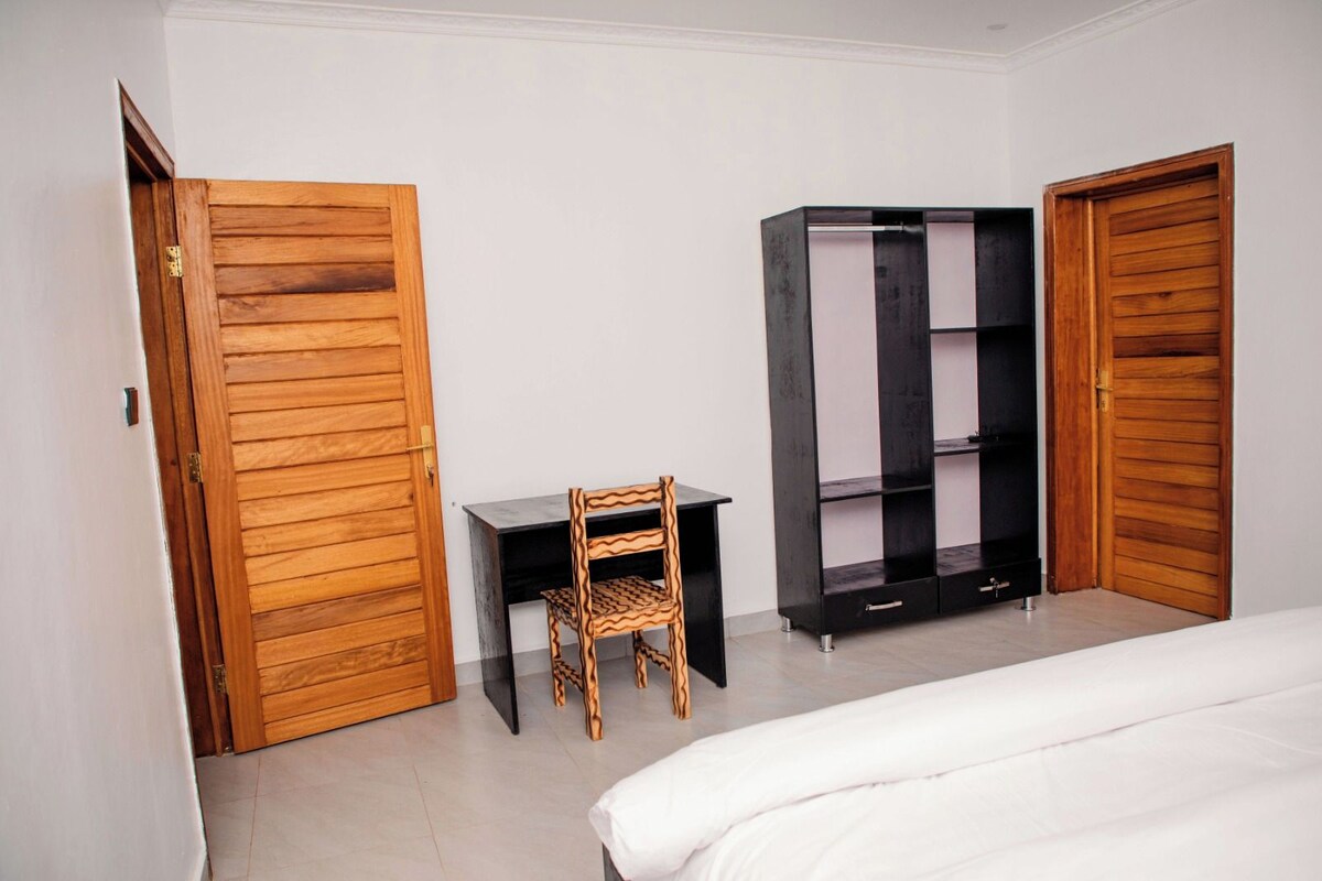 Een slaapkamer met een bed, een bureau en een kledingkast.