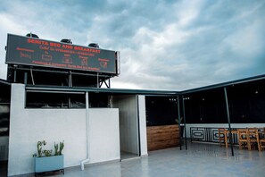 A modern building with a sign advertising Senita Bed and Breakfast, including amenities like bedrooms, TV, WiFi, shower, and breakfast. - Mutoni Teddy (Kigali)