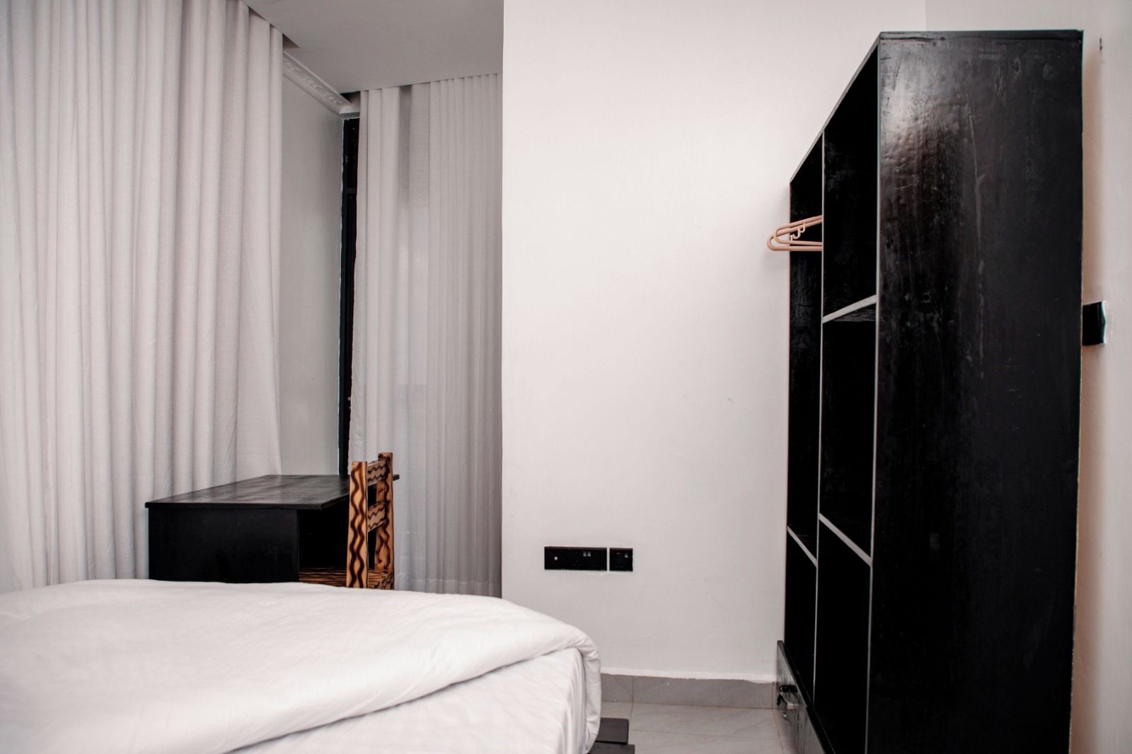 A bedroom with a bed, a wardrobe, and a mirror.