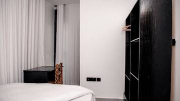 A bedroom with a bed, a wardrobe, and a mirror.