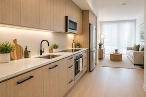 Una cocina moderna con armarios de madera, electrodomésticos de acero inoxidable y una isla central.