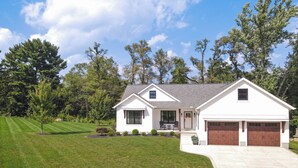 A single-story house with a front porch, a garage, and a well-maintained lawn. - Modern Farmhouse In Salem (Salem)