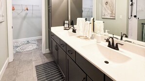 A modern bathroom with a double sink, a large mirror, and a shower area. - Modern Farmhouse In Salem (Salem)