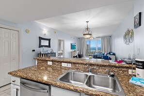 A modern kitchen with granite countertops, stainless steel sinks, and a built-in dishwasher. - Ariel Dunes II 909 (Miramar Beach)