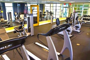 Ein Fitnessstudio mit Laufbändern, Kraftgeräten und Hanteln.