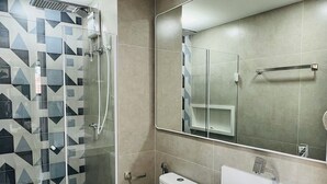 A modern bathroom with a glass-enclosed shower, a toilet, and a sink with a mirror above. - New and Modern • Partridges • 800m Allianz Parque • (São Paulo)