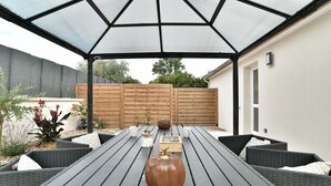 Eine Terrasse im Freien mit Tisch, Stühlen und einer dekorativen Kürbis-Zentralanordnung.