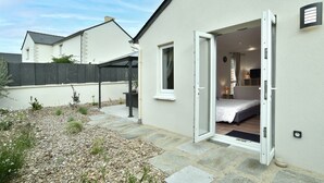 Ein Bungalow mit einem Schlafzimmer, das ein Bett, einen Nachttisch und eine Lampe bietet.