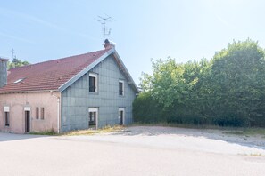 A two-story building with a red-tiled roof, a chimney, and a satellite dish. - Les Souvenirs du Reucy - vue montagne (La Bresse)