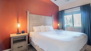 Ein Hotelzimmer mit einem Bett, Nachttischen und einem Fenster mit Vorhängen.