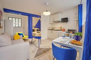 A modern apartment with a living room, a dining area, and a kitchenette. - Goshen - studio au coeur du centre historique (Bergerac)