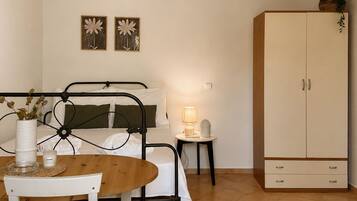 A compact bedroom with a bed, bedside table, lamp, and a wardrobe.