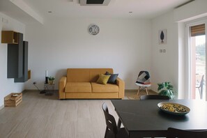 Ett modernt vardagsrum med en soffa, ett matbord och ett soffbord.