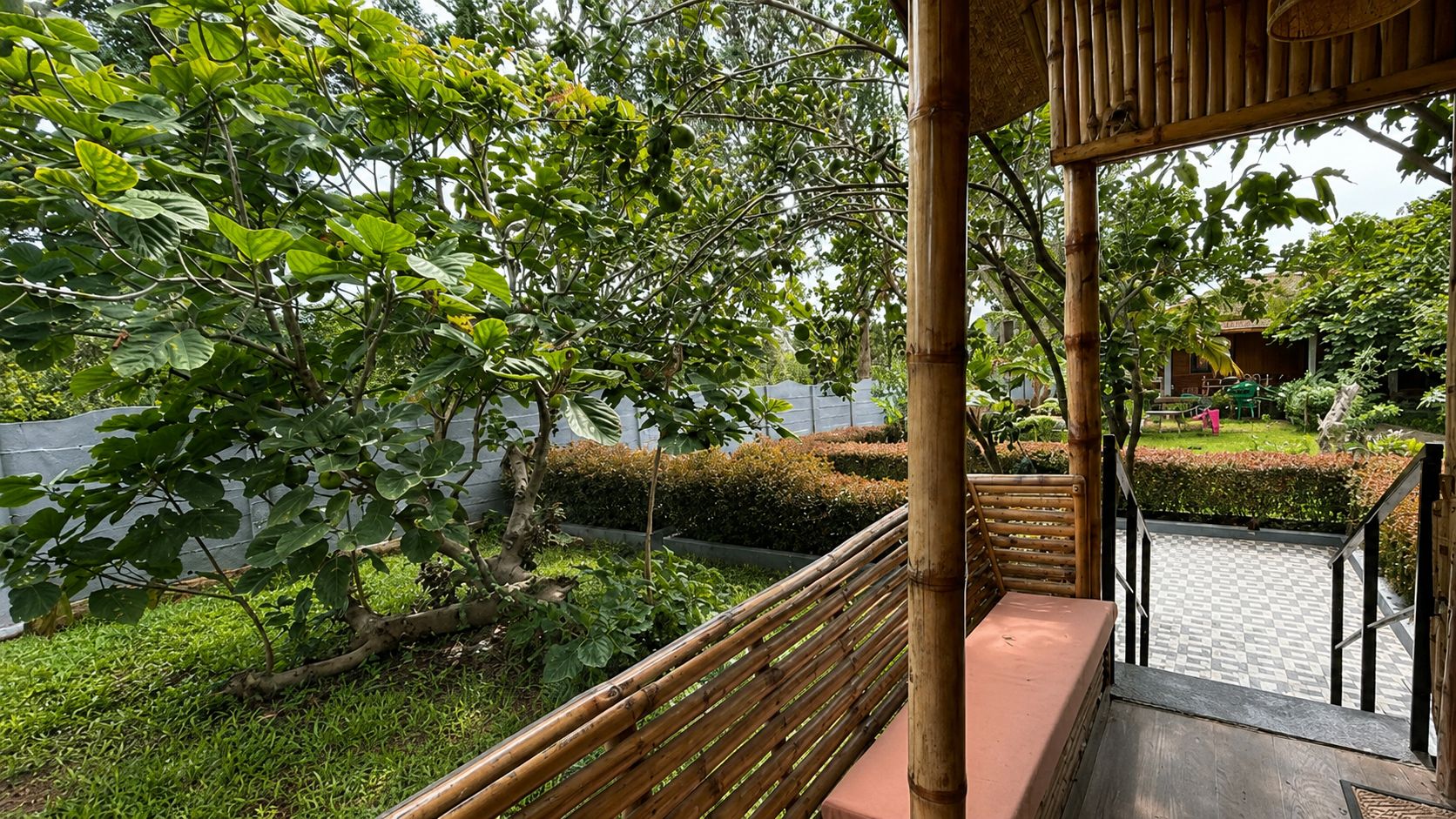 A bamboo structure with a checkered floor leading to a seating area.