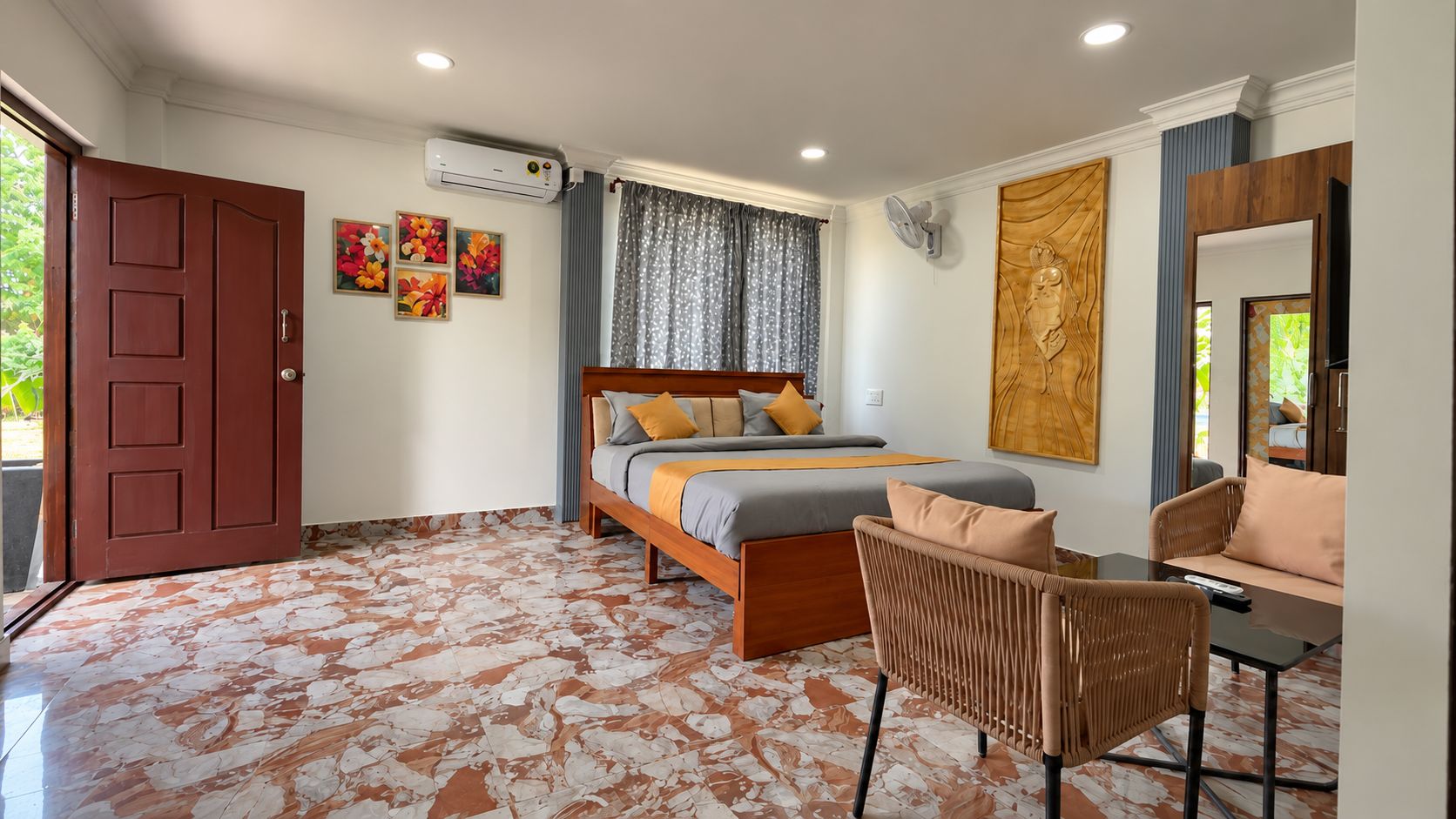 A bedroom with a bed, a chair, a sofa, and a large mirror.