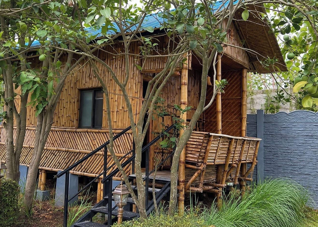 A bamboo structure with a staircase leading to a covered porch area.