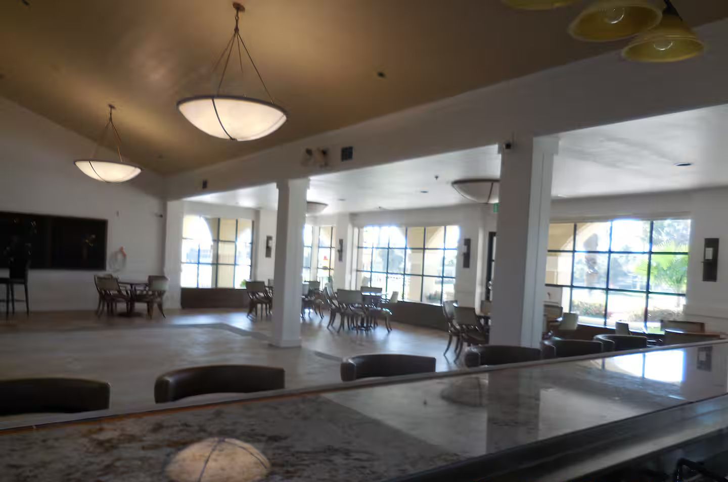 Spacious indoor clubhouse seating area with counter and large windows.